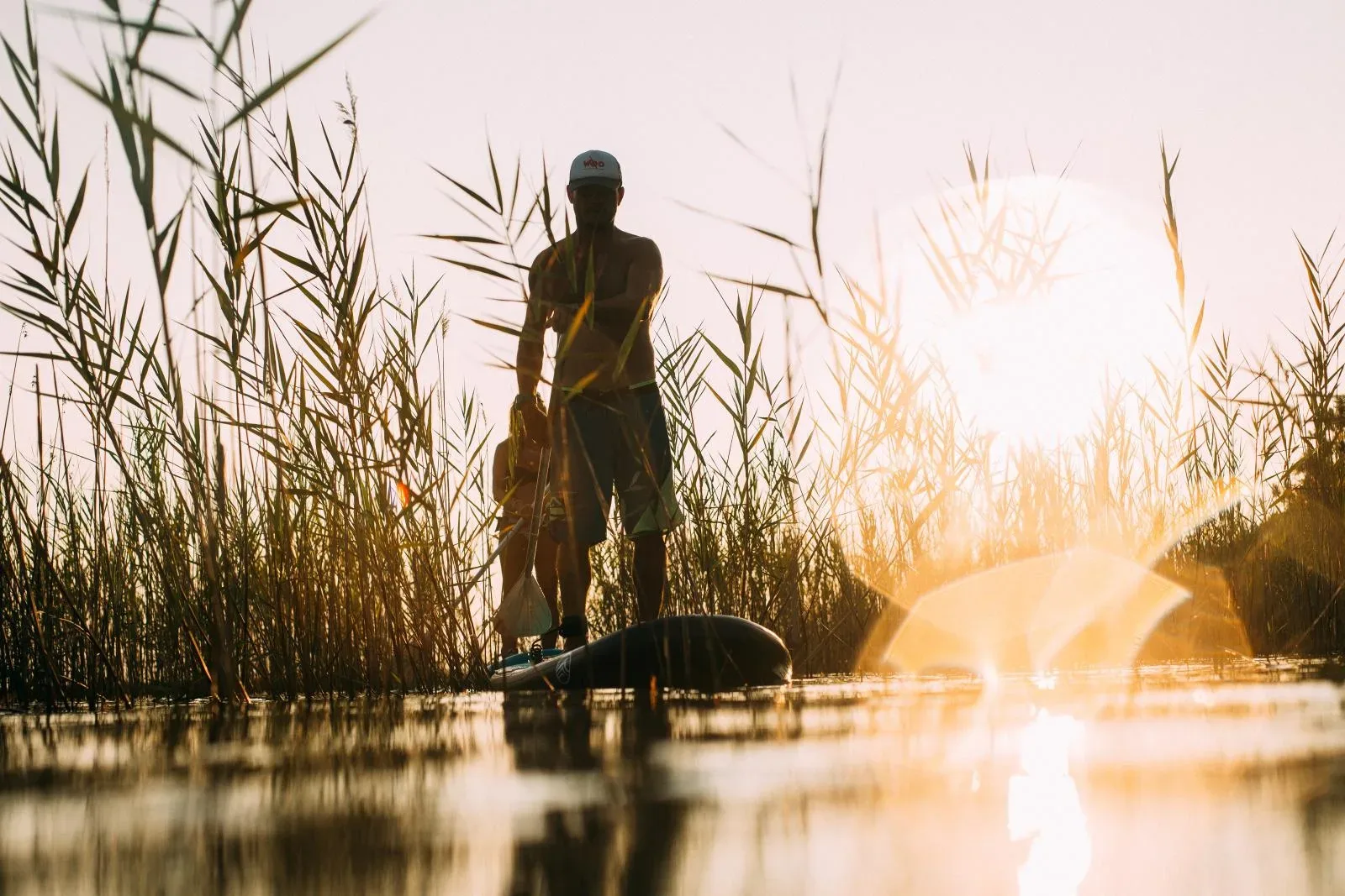 Stand-up paddle sur un lac landais au coucher de soleil